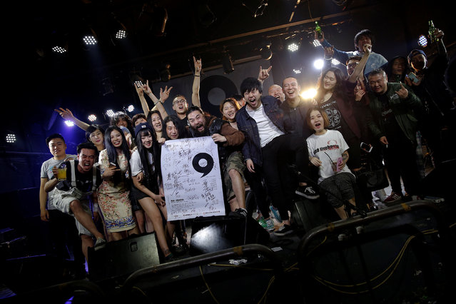 Lai Jinrong, a guitarist with the heavy metal band Logic Out of Control (C, holding poster) poses with staff of Mao Live House after the club's last public concert night in central Beijing, China April 24, 2016. (Photo by Damir Sagolj/Reuters)