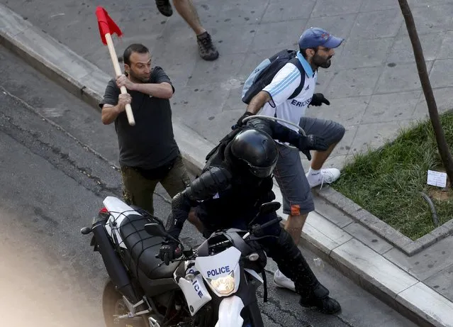 Anti-austerity demonstrators tussle with a motorcycle policeman in Syntagma Square in Athens during an anti-Austerity rally, Greece, July 3, 2015. An opinion poll on Greece's bailout referendum published on Friday pointed to a slight lead for the Yes vote, on 44.8 percent, against 43.4 percent for the No vote that the leftwing government backs. (Photo by Jean-Paul Pelissier/Reuters)