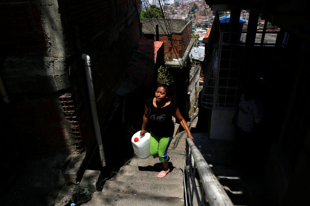 A woman carries a container filled with water up a flight of stairs at the slum of Petare in Caracas, Venezuela, March 17, 2016. (Photo by Carlos Garcia Rawlins/Reuters)