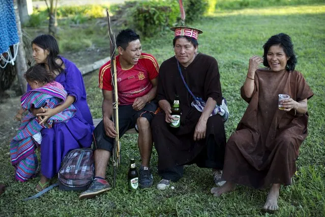 In this June 23, 2015 photo, Ashaninka Indians drink Peruvian beer as they wait for the start of band during the 44th anniversary celebrations of their village, in Otari Nativo, Pichari, Peru. Other activities included a beauty contest, an archery competition, and a drinking contest of the traditional fermented juice of cassava root, known locally as masato. (Photo by Rodrigo Abd/AP Photo)