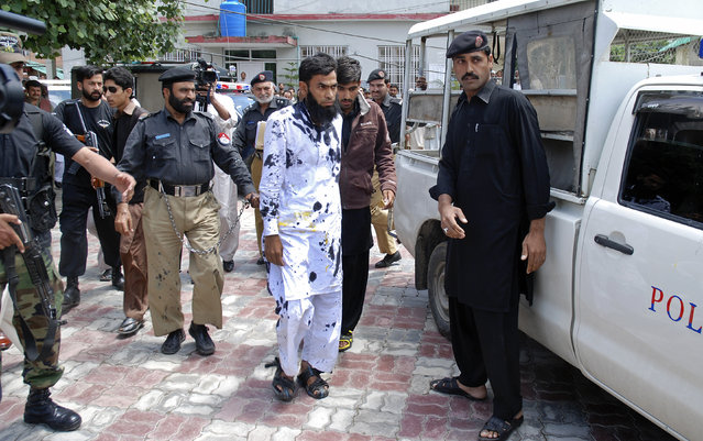 Pakistani suspects of a gang rape, center, leave a court after outraged citizens pelted the suspects with ink and tomatoes, in Mansehra, Pakistan, Wednesday, May 14, 2014. Pakistani police have arrested a seminary teacher and two of his friends on charges of gang raping a college girl in a city in the northwest, a police official said Wednesday. The case is unusual since rape cases are rarely prosecuted in Pakistan and women who complain are often stigmatized. (Photo by Aqeel Ahmad/AP Photo)