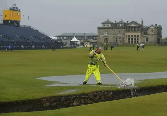 Groundstaff remove water from the course after torrential rain forced play to be suspended during the second round of the British Open golf championship on the Old Course in St. Andrews, Scotland, July 17, 2015. (Photo by Lee Smith/Reuters)