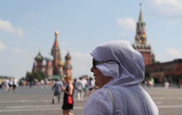 People walk on the Red Square outside the Kremlin in Moscow, Russia, 02 July 2024. The temperature in Moscow exceeded 32 degrees Celsius. (Photo by Maxim Shipenkov/EPA/EFE)