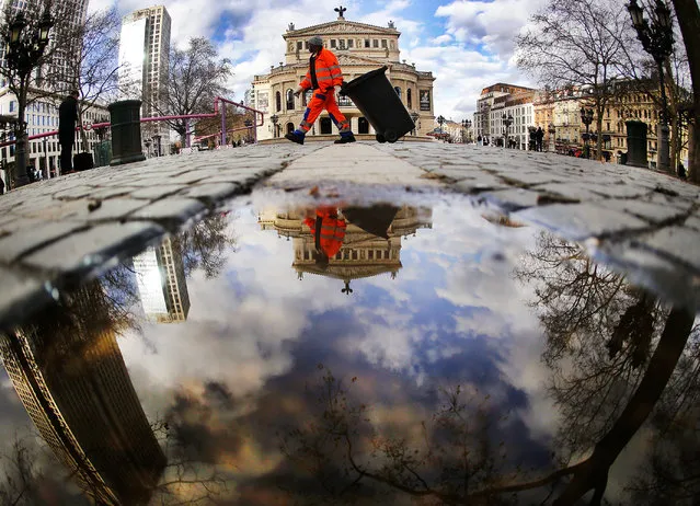 A man empties waste paper baskets in front of the Old Opera in Frankfurt, Germany, Thursday, March 2, 2017. (Photo by Michael Probst/AP Photo)