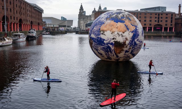 People paddle board around Luke Jerram's “Floating Earth” art installation in the Albert Dock as part of the Eurovision celebrations in Liverpool, Britain on April 30, 2023. (Photo by Phil Noble/Reuters)