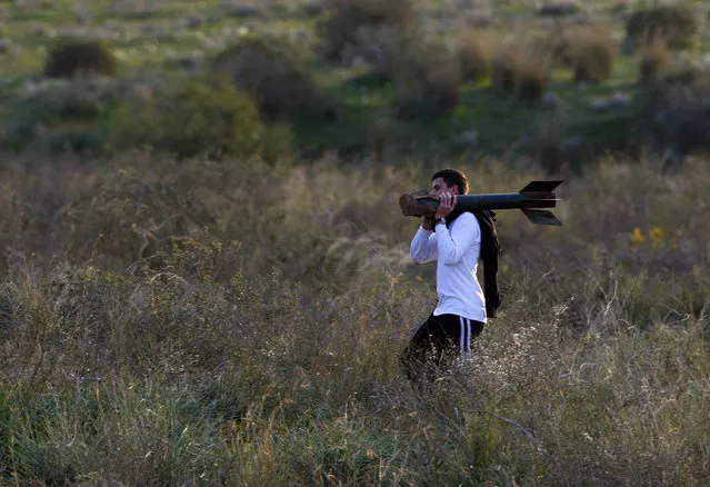 An Israeli youth carries the remains of a rocket fired by Palestinian militants in Gaza after it landed near Kibbutz Nir Am, just outside the northern Gaza Strip January 14, 2009. (Photo by Yannis Behrakis/Reuters)
