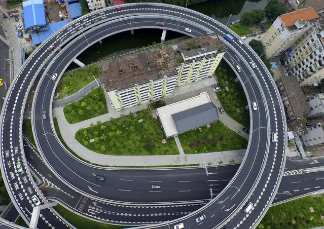 An old residential building is seen surrounded by a newly-built ring viaduct, in Guangzhou, Guangdong province, China, June 18, 2015. The building was planned to be demolished, but several units in the building refused to move out as they couldn't reach a compensation agreement with the authority, local media reported. (Photo by Ma Qiang/Reuters/Southern Metropolis Daily)