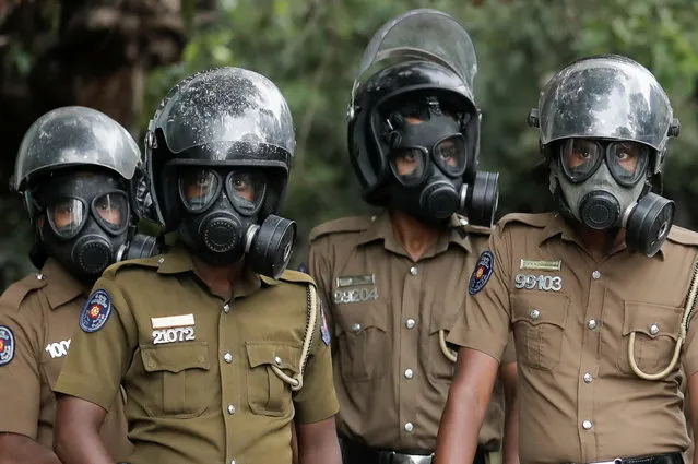 Sri Lanka police officers wearing gas masks stand guard on a road leading to the parliament building, after the government of President Gotabaya Rajapaksa lost its majority, amid the country's economic crisis, in Colombo, Sri Lanka, April 5, 2022. (Photo by Dinuka Liyanawatte/Reuters)