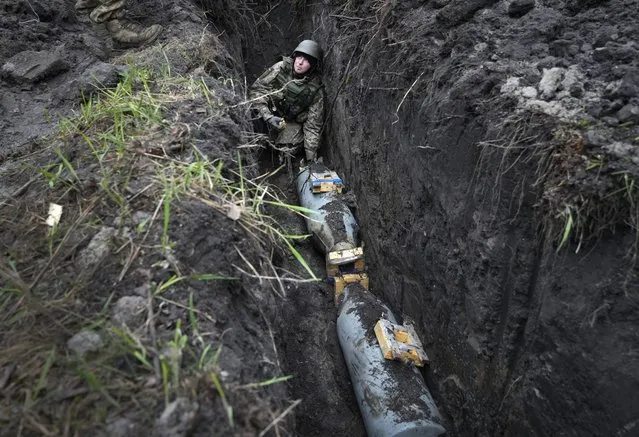 A Ukrainian sapper prepares to detonate a Russian 250-kilogram air bomb in the village of Kolonshchyna, Ukraine, Thursday, April 21, 2022. (Photo by Efrem Lukatsky/AP Photo)