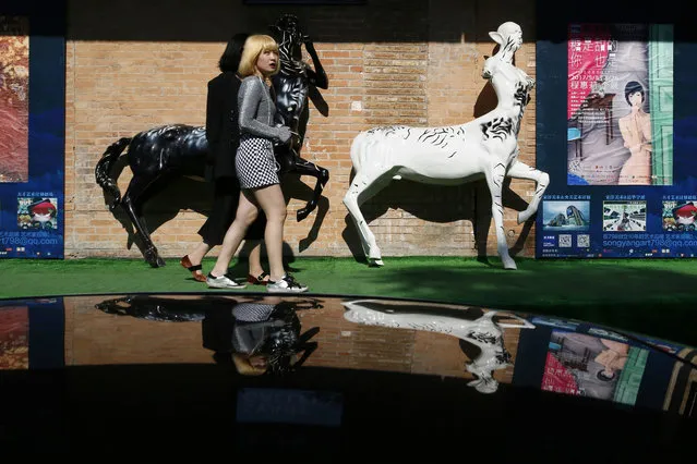 Visitors to the 798 art district walk past art installations outside a gallery in Beijing Tuesday, May 23, 2017. (Photo by Ng Han Guan/AP Photo)