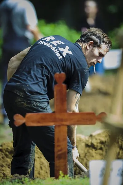 A gravegdigger competes during the first National Grave Digging Competition  at the public cemetery of Debrecen, 226 kms east of Budapest, Hungary, Friday, June 3, 2016. (Photo by Zsolt Czegledi/MTI via AP Photo)
