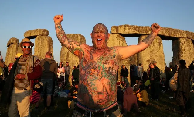 A reveler called Mad Alan (real name) celebrates the 2014 summer solstice, the longest day of the year, at sunrise at the prehistoric monument Stonehenge, near Amesbury in Southern England, on June 21, 2014. The festival, which dates back thousands of years, celebrates the longest day of the year when the sun is at its maximum elevation. Modern druids and people gather at the landmark Stonehenge every year to see the sun rise on the first morning of summer. (Photo by Geoff Caddick/AFP Photo)