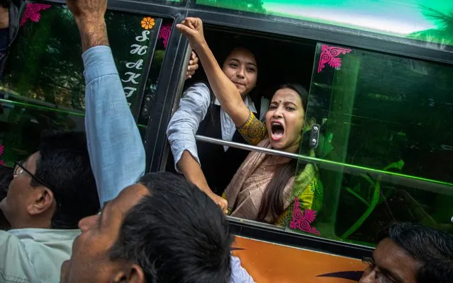 A woman shouts slogans from inside a bus after being detained during a protest against the Citizenship Amendment Act in Gauhati, India, Tuesday, December 17, 2019. Indian student protests that turned into violent clashes with police galvanized opposition nationwide on Tuesday to a new law that provides a path to citizenship for non-Muslim migrants who entered the country illegally from several neighboring countries. (Photo by Anupam Nath/AP Photo)