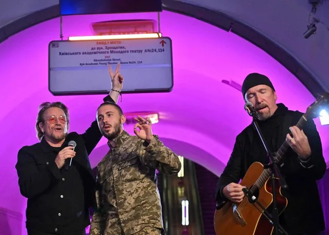 Bono (Paul David Hewson), an Irish singer-songwriter, activist, and the lead vocalist of the rock band U2, and Antytila (C), a Ukrainian musical band leader and now the serviceman in the Ukrainian Army Taras Topolia, perform at subway station which is bomb shelter, in the center of Ukrainian capital of Kyiv on May 8, 2022. (Photo by Sergei Supinsky/AFP Photo)