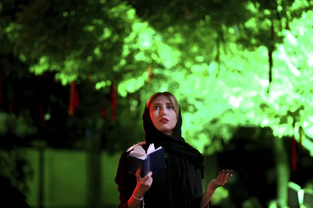 An Iranian Shiite Muslim prays in Laylat al-Qadr, or the night of destiny, during holy fasting month of Ramadan after midnight, in central Tehran, Iran, early Sunday, June 18, 2017. Laylat al-Qadr is the night when Muslims believe the Quran was first revealed to prophet Muhammad. Worshipers gather in religious ceremonies to pray, ask forgiveness and make wishes on one of the most important nights of the Islamic calendar. Shiite Muslims, the vast majority of Iranians, believe the night happens either on 19th, 21st or 23rd of the holy month of Ramadan. (Photo by Ebrahim Noroozi/AP Photo)