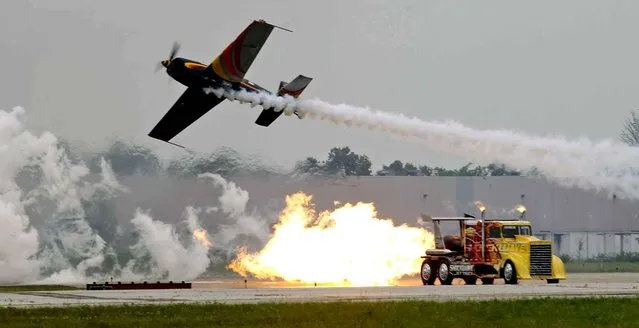 Patty Wagstaff flies by the Shockwave truck during the Dayton air show on Saturday, June 28, 2014, in Dayton, Ohio. (Photo by Ty Greenlees/AP Photo/The Dayton Daily News)