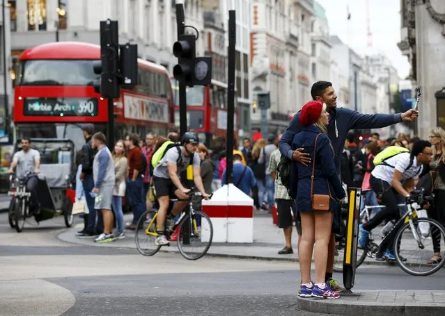 A couple take a selfie as commuters travel home through Oxford Circus during a 24 hour strike by in London, Britain August 5, 2015. Londoners face major transport disruption from Wednesday evening as train drivers and staff on the underground rail network walk out for the second time in less than a month. Unions are angry over plans to introduce a new night service from September and weeks of talks with transport bosses have failed to clinch a deal over pay and conditions. (Photo by Darren Staples/Reuters)