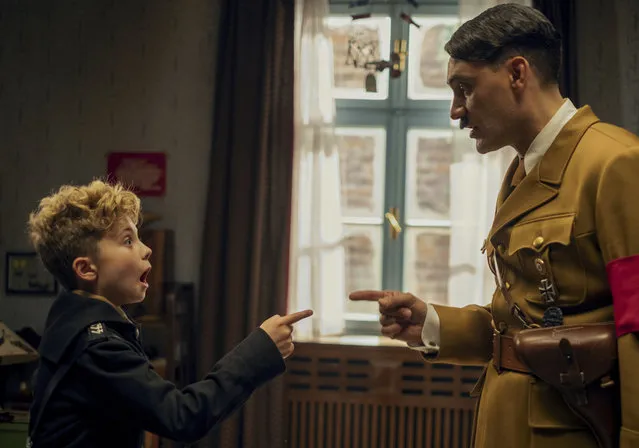 This image released by Fox Searchlight Pictures shows, from left, Roman Griffin Davis and Taika Waititi in a scene from the WWII satirical film “Jojo Rabbit”. (Photo by Kimberley French/Fox Searchlight Pictures via AP Photo)