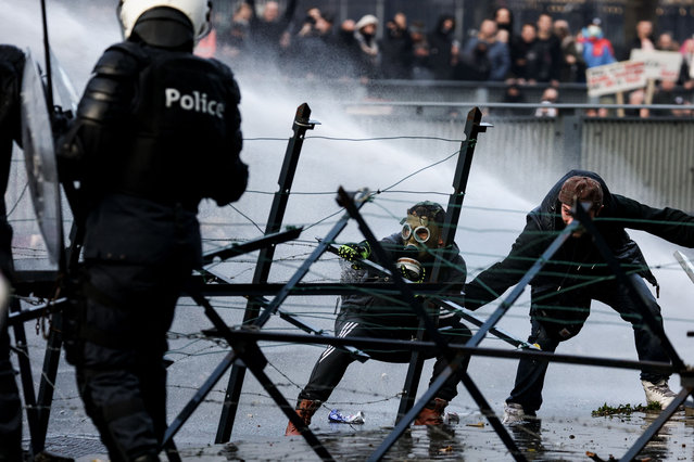 Police use water canon to disperse demonstrators as clashes erupt during a demonstration against Covid-19 measures, including the country's health pass, in Brussels on November 21, 2021. (Photo by Kenzo Tribouillard/AFP Photo)
