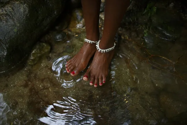 The bare feet of a devotee are pictured as she takes a dip at the Bagmati River during the “Bol Bom” (Say Shiva) pilgrimage in Kathmandu July 21, 2014. The faithful, chanting the name of Lord Shiva, run about 15 km (9 miles) barefooted toward Pashupatinath temple seeking good health, wealth and happiness. (Photo by Navesh Chitrakar/Reuters)
