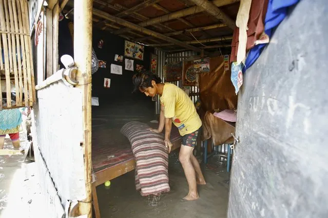 A man recovers a mattress from his room after floodwaters caused by heavy rainfall flowing from the swollen Bagmati River, entered a slum in Kathmandu, Nepal August 17, 2015. (Photo by Navesh Chitrakar/Reuters)