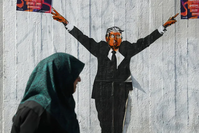 A Muslim woman walks past a street artist's rendition of U.S. President Donald Trump on June 27, 2017 in Berlin, Germany. The U.S. Supreme Court recently partially lifted a blockade by lower courts of Trump's travel ban on people from six predominantly Muslim countries, though the court decision allows people with a viable connection to the U.S., for instance through family, study or work, to still enter the U.S. (Photo by Sean Gallup/Getty Images)