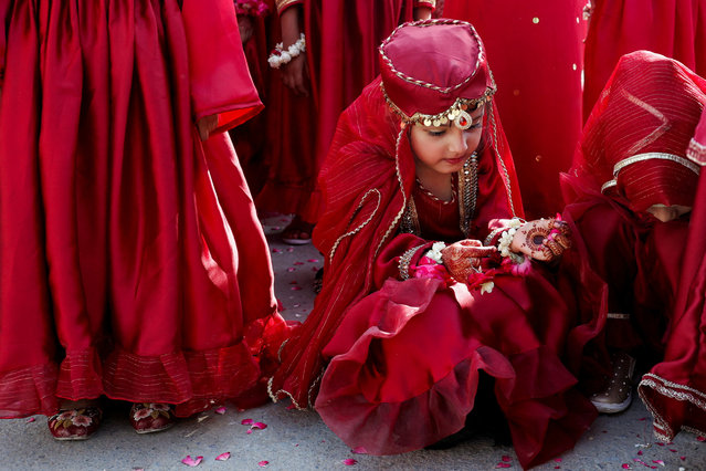 A student in red attire sits along with others as they attend the Eid-e-Milad-ul-Nabi celebrations, the birth anniversary of the Prophet Mohammad, in Karachi, Pakistan on September 17, 2024. (Photo by Akhtar Soomro/Reuters)