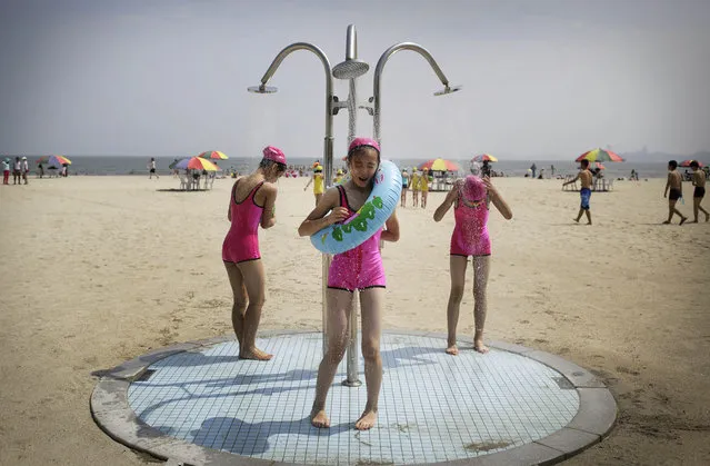 North Korean girls in similar bathing suits stand under a shower at the Songdowon International Children's Camp, Tuesday, July 29, 2014, in Wonsan, North Korea. The camp, which has been operating for nearly 30 years, was originally intended mainly to deepen relations with friendly countries in the Communist or non-aligned world. But officials say they are willing to accept youth from anywhere – even the United States. (Photo by Wong Maye-E/AP Photo)