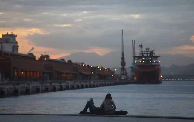 People sit along Guanabara Bay in the renovated port district, an area aiming to attract tourists, on August 23, 2017 in Rio de Janeiro, Brazil. Rio de Janeiro's hotels have reported a fifty percent drop in expected reservations for the upcoming New Year's and Carnival holidays. Factors include the economic crisis in Brazil, a spike in urban crime and violence and an expanded number of hotel rooms constructed in the run up to the Olympics. (Photo by Mario Tama/Getty Images)