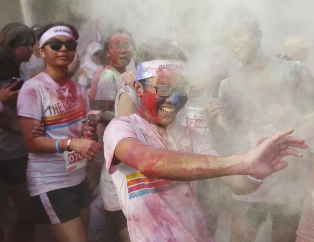 A man reacts as coloured powder is thrown at him during the Color Run in Kuala Lumpur August 17, 2014. (Photo by Olivia Harris/Reuters)