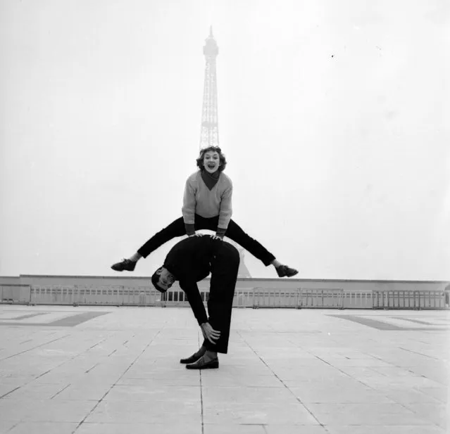 Paris street performers Jean Louis Bert and Grethe Bulow playing leap-frog in front of the Eiffel Tower, 1955.  (Photo by Jean Berton)