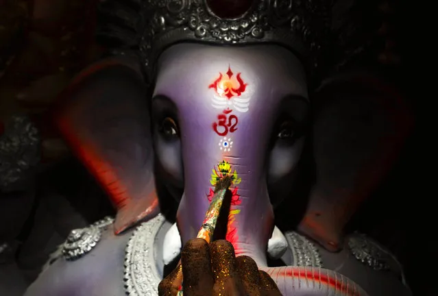 An Indian artist paints an idol of Hindu elephant-headed god Lord Ganesha during preparations for the upcoming Ganesha Chaturthi festival at a roadside workshop in Bangalore, India, August 25, 2014. The ten-day long Hindu festival is celebrated as the birthday of Lord Ganesha and starts on 29 August. (Photo by Jagadeesh Nv/EPA)