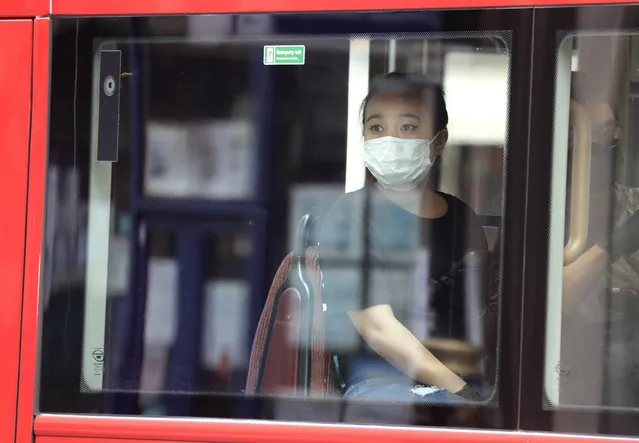 A woman wears a mask to protect against the coronavirus as she looks out of the window of a bus in London, Monday, May 4, 2020, as the UK enters a seventh week of lockdown to help stop the spread of coronavirus. The highly contagious COVID-19 coronavirus has impacted on nations around the globe, many imposing self isolation and exercising social distancing when people move from their homes. (Photo by Kirsty Wigglesworth/AP Photo)