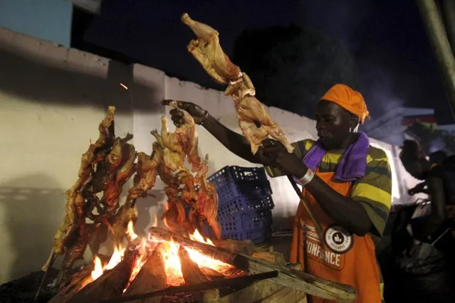 A cook grills chicken during the Festival des Grillades, in the yard of the Culture Palace of Abidjan, September 5, 2015. (Photo by Luc Gnago/Reuters)