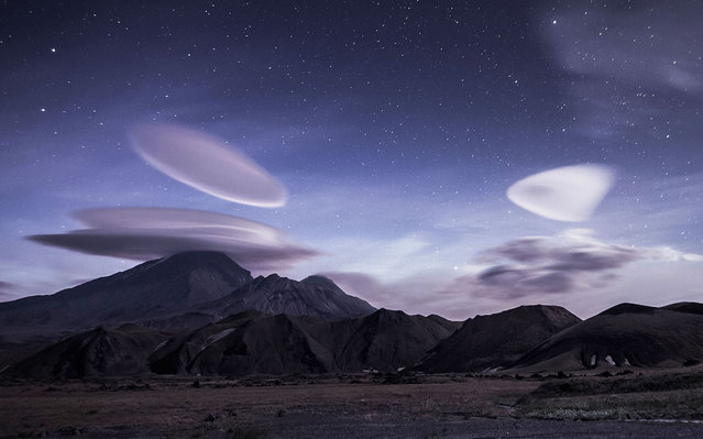 These stunning images have captured “UFO” type clouds forming around world famous volcano. The Kamchatka peninsula contains the volcanoes of Kamchatka, which have been captured in a series of stunning shots by photographer Vladimir Voychuk, 37, from Klin, Russia. It is said that Kamchatka is one of the most picturesque distant corners of huge Russia and attracts hundreds of photographers with its unique nature. The volcanoes can be seen to be surrounded by lenticular clouds, stationary lens-shaped clouds that form in the troposphere. Because of their shape, they have been offered as an explanation for some unidentified flying object (UFO) sightings. Vladimir said: “It is probably one of my favourite places to take pictures despite the distance from the city that I live in, and I never miss out on an opportunity to visit. My aim this time was to capture the volcanoes alongside these fantastic looking clouds. They often remind people of alien space ships forming around the volcanoes”. Here: The stunning Kamchatka Peninsula, Russia. (Photo by Vladimir Voychuk/Caters News)