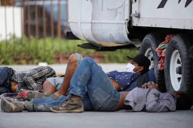 Migrants rest beside a truck outside the migrant shelter “Casa INDI”, where some migrants have been infected by the coronavirus disease (COVID-19), in Monterrey, Mexico on June 12, 2020. (Photo by Daniel Becerril/Reuters)