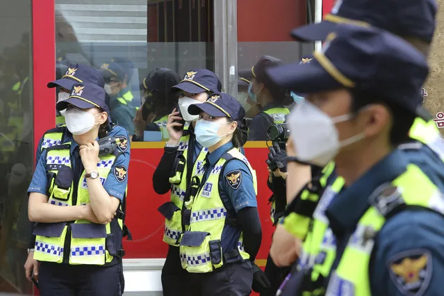 Police officers wearing face masks to help protect against the spread of the new coronavirus stand guard during a rally near the Chinese embassy in Seoul, South Korea, Thursday, June 4, 2020. (Photo by Ahn Young-joon/AP Photo)