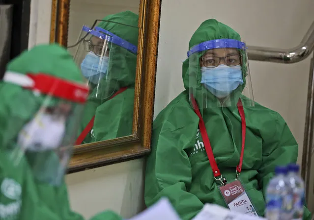 Health workers wait for patients during a mass test for the new coronavirus at the local district office in Tanah Abang in Jakarta, Indonesia, Sunday, June 21, 2020. (Photo by Dita Alangkara/AP Photo)