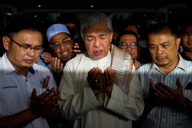Former Malaysia deputy prime minister Ahmad Zahid Hamidi (C) prays with his supporters while leaving the Shah Alam High Court, in Shah Alam, Malaysia, 23 September 2022. Zahid was acquitted of 40 charges of receiving bribes from a company to extend its foreign visa system (VLN) contract. (Photo by Fazry Ismail/EPA/EFE)