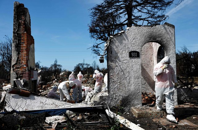 Volunteers with Samaritan's Purse help homeowner Dennis Higgins (NOT PICTURED) search for meaningful personal items in the remains of his home which burned in the Palisades Fire on March 15, 2025 in Pacific Palisades, California. Higgins and his wife Nicole had lived in the home for about 30 years. Over 16,000 structures were destroyed in the Palisades and Eaton fires. (Photo by Mario Tama/Getty Images/AFP Photo)