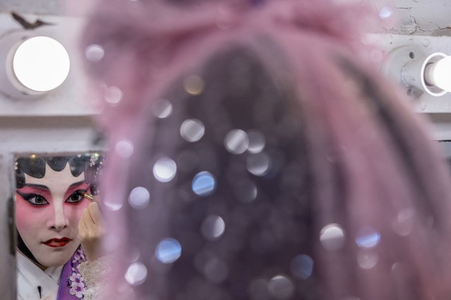 Rika Woo, 31, a Cantonese opera performer and a captain of an underground J-pop style idol group, dressed in traditional Cantonese opera attire, applies makeup before an opera performance in Hong Kong, China, on October 30, 2024. (Photo by Tyrone Siu/Reuters)
