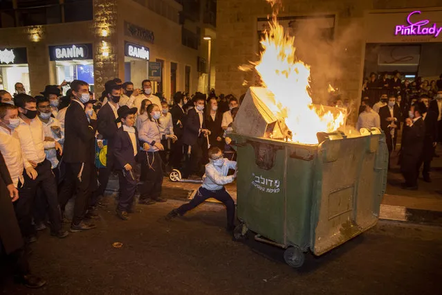 Ultra-Orthodox Jews burn a dumpster during a protest against lockdown that has been placed in their neighborhood due to a coronavirus outbreak, in Jerusalem, Monday, July 13, 2020. As Israel grapples with a spike in coronavirus cases, it has begun to impose restrictions on selected towns and neighborhoods with high infection rates. Many of these areas are ultra-Orthodox, and residents say they are being unfairly singled out. (Photo by Oded Balilty/AP Photo)