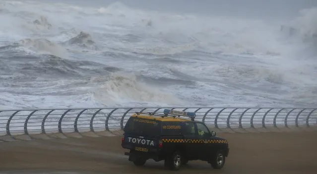 A coastguard vehicle drives along the promenade as waves crash into the shoreline at Blackpool in northern England October 21, 2014. Britain is facing strong winds and rain from the remnants of Hurricane Gonzalo, local media reported. (Photo by Andrew Yates/Reuters)