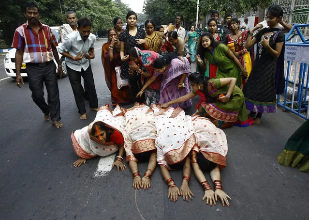 Hindu devotees lie on a road as they worship the Sun god Surya during the Hindu religious festival of Chatt Puja in Kolkata October 29, 2014. (Photo by Rupak De Chowdhuri/Reuters)