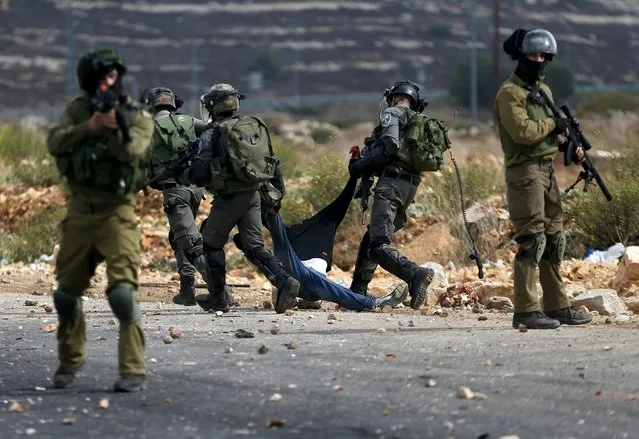 Israeli border police detain a wounded Palestinian protester during clashes near the Jewish settlement of Bet El, near the West Bank city of Ramallah, October 7, 2015. (Photo by Mohamad Torokman/Reuters)