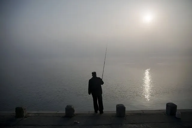 A man fishes amid morning fog over Taedong River in Pyongyang, North Korea October 8, 2015. (Photo by Damir Sagolj/Reuters)