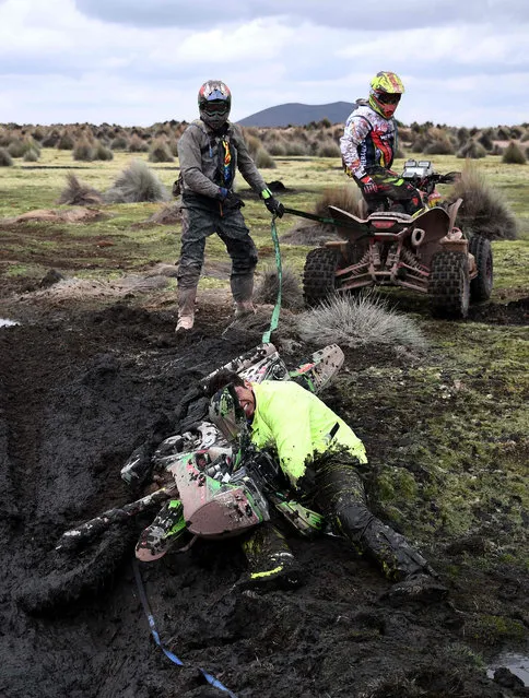 Chilean rider Patricio Cabrera is helped by other competitors during Stage 7 of the 2018 Dakar Rally between La Paz and Uyuni, Bolivia, on January 13, 2018. (Photo by Franck Fife/AFP Photo)