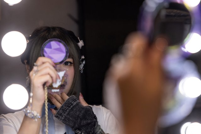 Rika Woo, 31, a Cantonese opera performer and a captain of underground J-pop style idol group Otome Syndream, applies makeup before a performance in Hong Kong, China, on November 17, 2024. (Photo by Tyrone Siu/Reuters)