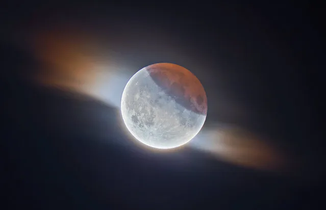 Our moon runner-up: Partial Lunar Eclipse with Clouds by Ethan Roberts (UK). During the 2019 partial lunar eclipse, the photographer managed to capture this fantastic image of the moon while a small cloud passed in front of it. You can see the Earth’s shadow on the top right and its striking orange colour caused by the sun’s light passing through the atmosphere. This is a high dynamic range image, meaning the darker, shadowed region is correctly exposed as well as the much brighter parts of the moon. (Photo by Ethan Roberts/2020 Astronomy Photographer of the Year)