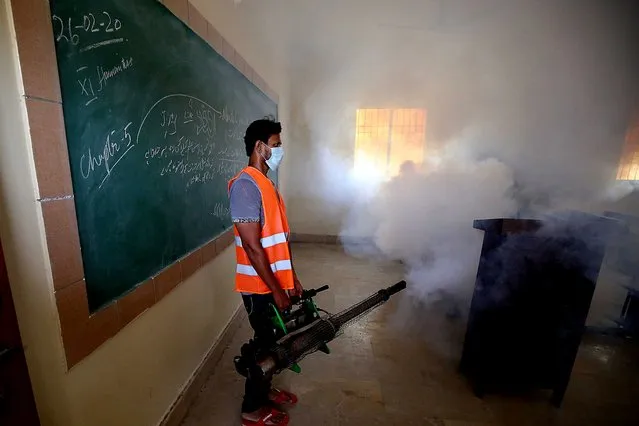 A Pakistani health worker disinfects a classroom before the reopening of educational institutes in Karachi, Pakistan, 10 September 2020. The Pakistani government on 07 September announced the opening of educational institutions in the country in phases starting on 15 September, as cases of COVID-19 infections continue to decline. (Photo by Shahzaib Akber/EPA/EFE)